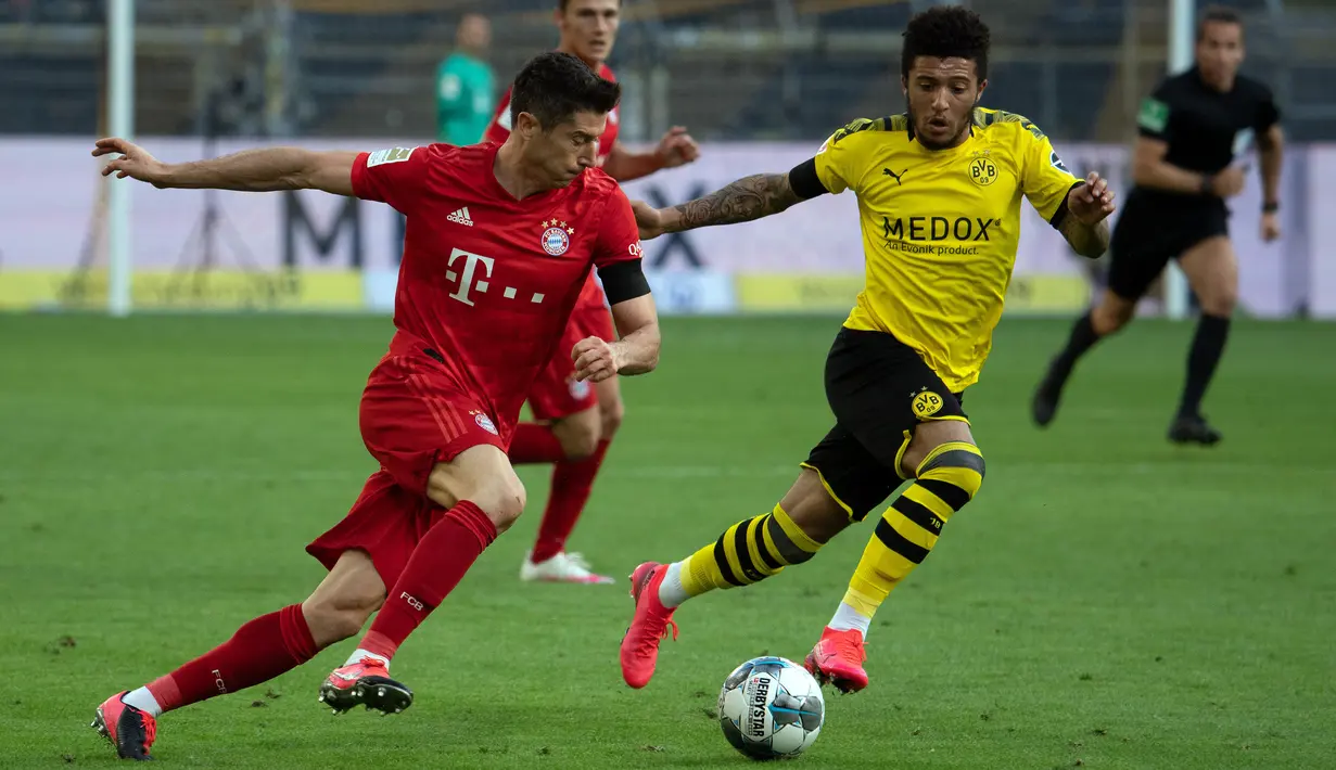 Striker Bayern Munchen, Robert Lewandowski, berebut bola dengan gelandang Borussia Dortmund, Jadon Sancho, pada laga pekan ke-28 Bundesliga di Stadion Signal Iduna Park, Selasa (26/5/2020) waktu setempat. Bayern Munchen menang 1-0 atas Borussia Dortmund. (AFP/Federico Gambarini/Pool)