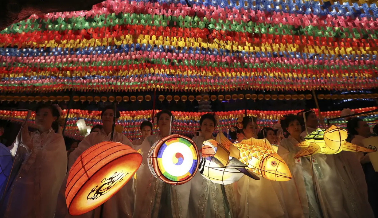 Sejumlah wanita membawa lampion beraneka bentuk saat Lotus Lantern Festival di Seoul, Korea Selatan, Sabtu (29/4). Parade ini bagian dari jelang perayaan ulang tahun Buddha yang jatuh pada 3 Mei 2017. (AP Photo / Lee Jin-man)