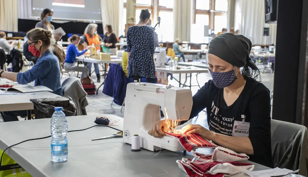 Para sukarelawan membuat masker di Balai Kota Lille, Lille, Prancis, Kamis (23/4/2020). Lebih dari 60 sukarelawan di tempat ini dapat memproduksi 1.500 hingga 2.000 masker kain setiap pekan untuk rumah sakit- rumah sakit setempat. (Xinhua/Sebastien Courdji)
