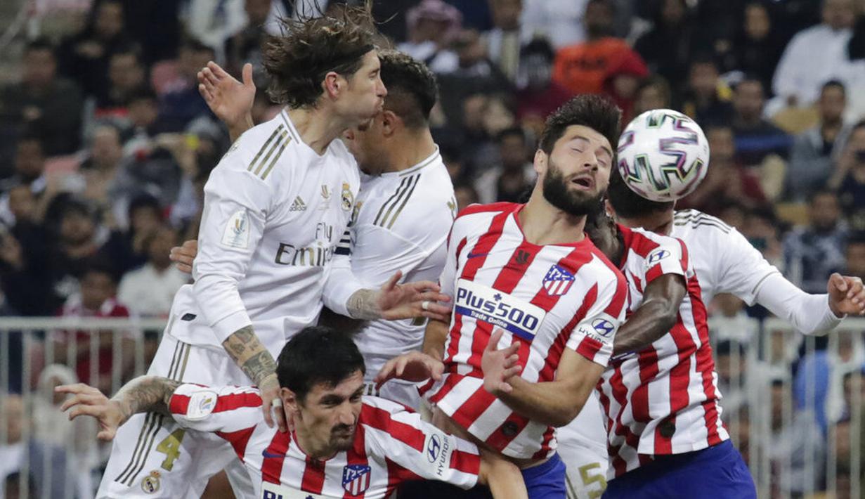 Pemain Real Madrid duel udara dengan pemain Atletico Madrid pada laga Piala Super Spanyol di King Abdulla Sports City, Jeddah, Senin (13/1/2020). Real Madrid menang adu penalti 4-1 atas Atletico Madrid. (AP/Hassan Ammar)
