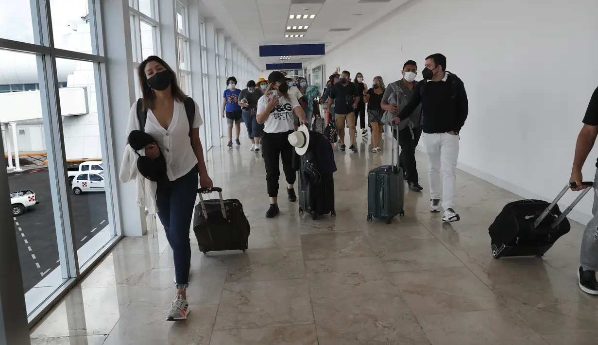 Para turis tiba di Bandara Cancun sebelum kedatangan Badai Grace, di Meksiko, Rabu (18/8/2021). Badai tropis Grace yang menguat menjadi badai pada 18 Agustus 2021 meluncur ke arah pantai Karibia, Meksiko dan mengancam akan membawa hujan lebat, banjir bandang dan gelombang besar. (AP/Marco Ugarte)