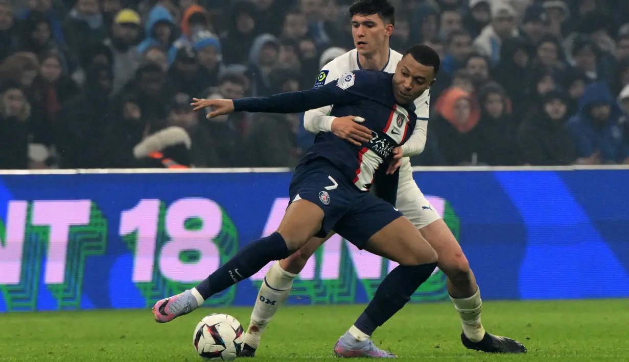 Penyerang Paris Saint-Germain (PSG) Kylian Mbappe berebut bola dengan bek Marseille Leonardo Balerdi dalam laga pekan ke-25 Liga Prancis 2022-2023, di Stadion Velodrome pada Senin (27/2/2023) dini hari WIB. Kylian Mbappe mencapai 200 gol dalam 245 penampilan. (NICOLAS TUCAT / AFP)