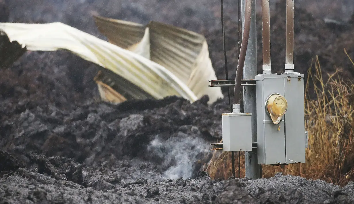 Lahar dingin dari letusan gunung berapi Kilauea menutupi jalan di Hawaii (8/5). Usai letusan gunung berapi tersebut lahar dingin memenuhi jalan dan memutus lalu lintas. (Mario Tama / Getty Images / AFP)