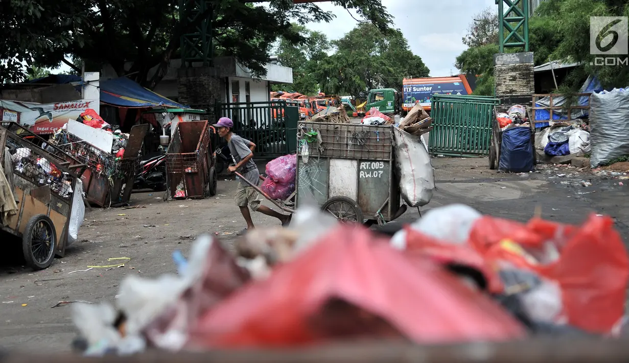 Petugas pengangkut sampah melintas di depan proyek Fasilitas Pengelolahan Sampah Terpadu atau Intermediate Treatment Facility (ITF) Sunter, Jakarta, Selasa (12/2). ITF Sunter ditargetkan beroperasi pada 2021. (Merdeka.com/Iqbal Nugroho)