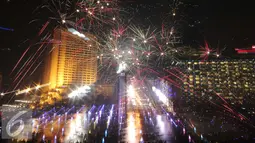 Kembang api menghiasi langit di kawasan Bundaran HI, Jakarta, Jumat (1/1/2016) malam. Kemeriahan kembang api tersebut merupakan bentuk perayaan pergantian tahun 2015 menuju 2016. (Liputan6.com/Angga Yuniar)