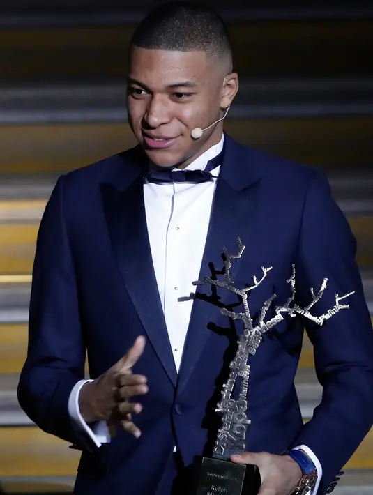 Striker Paris Saint-Germain, Kylian Mbappe menerima penghargaan Trophee Kopa pada seremoni Ballon d'Or 2018 di Grand Palais, Senin (3/12). Mbappe menjadi pemain pertama dalam sejarah yang memenangi penghargaan Trophee Kopa. (AP/Christophe Ena)