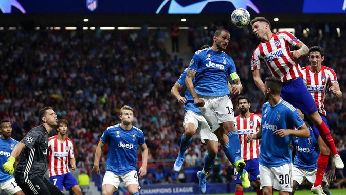 Gelandang Atletico Madrid, Saul, duel udara dengan bek Juventus, Leonardo Bonucci, pada laga Liga Champions di Stadion Wanda Metropolitano, Rabu (18/9/2019). Kedua tim bermain imbang 2-2. (AP/Manu Fernandez)