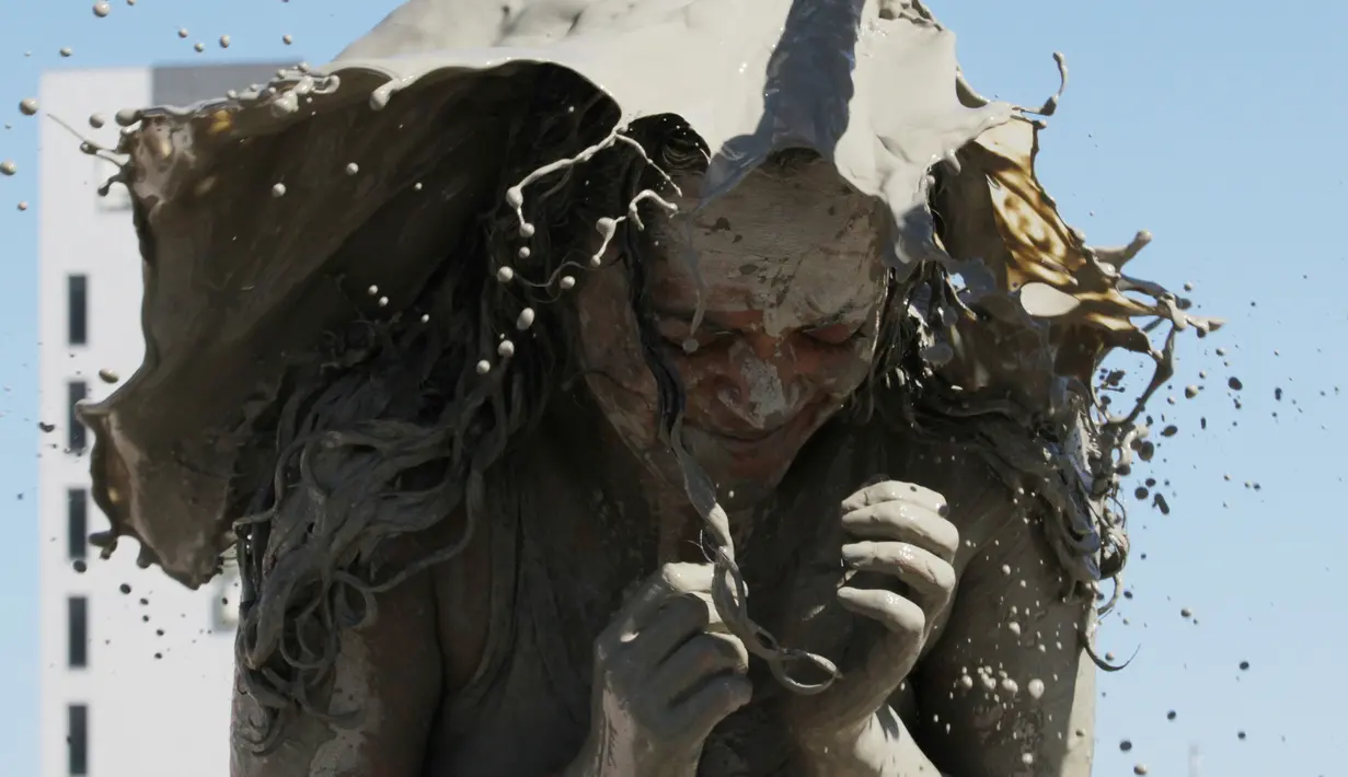 Seoarang wanita terkena air lumpur selama Festival Lumpur Boryeong di Pantai Daecheon di Boryeong, Korea Selatan, (14/7). Festival lumpur tahunan ke-21 ini menampilkan gulat lumpur. (AP Photo / Ahn Young-joon)