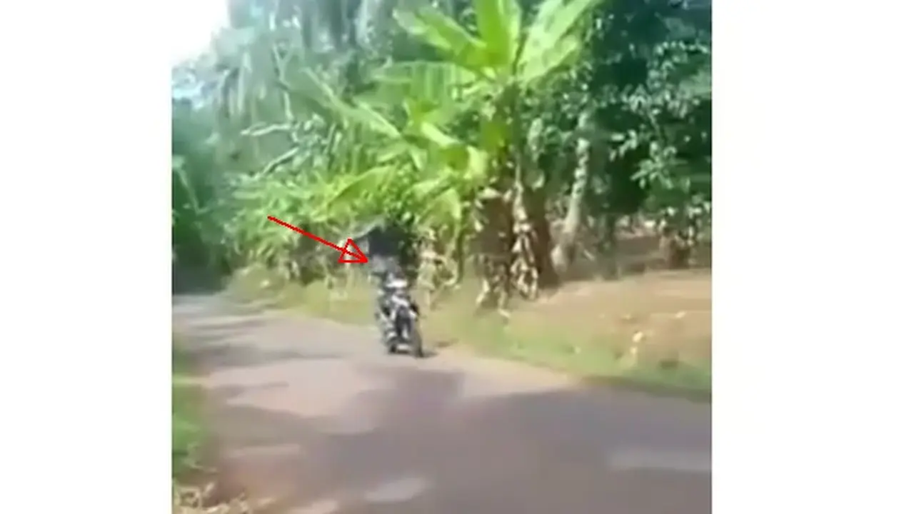 Berdiri di atas sepeda motor.