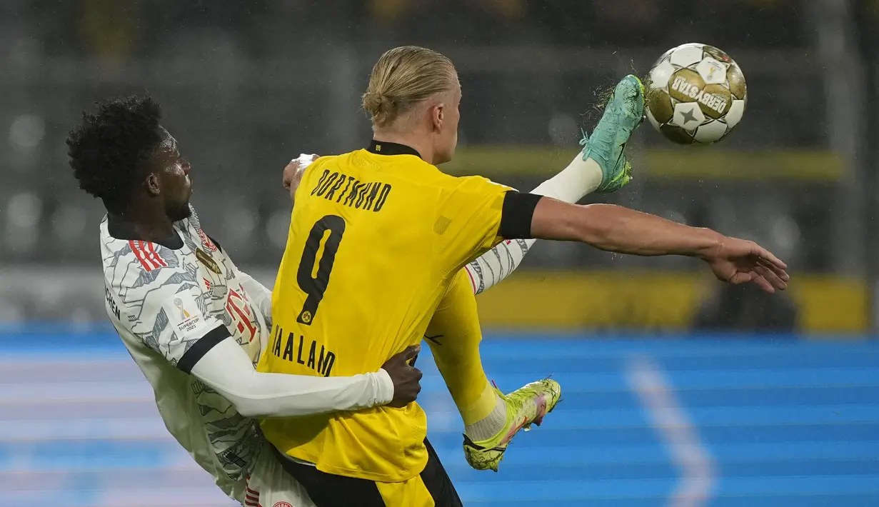 Penyerang Borussia Dortmund, Erling Haaland mengontrol bola dari kawalan bek Bayern Munchen, Alphonso Davies pada pertandingan final final Piala Super Jerman di Signal Iduna Park, Jerman, Rabu (18/8/2021). Munchen menang atas Dortmund dengan skor 3-1. (AP Photo/Martin Meissner)