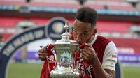 Striker Arsenal Pierre-Emerick Aubameyang mencium trofi Piala FA usai mengalahkan Chelsea 2-1 pada laga final di Stadion Wembley, Sabtu (1/8/2020) malam WIB. (foto: Adam Davy/Pool via AP)