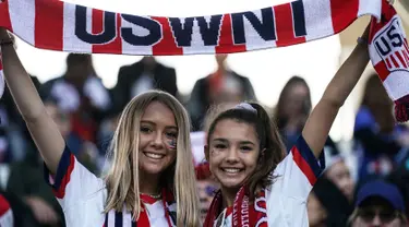 Dua fans wanita AS membentangkan syal sebelum pertandingan Grup F Piala Dunia Wanita 2019 antara Amerika Serikat melawan Thailand di Stadion Auguste-Delaune di Reims, Prancis (11/6/2019). (AFP Photo/Lionel Bonaventure)