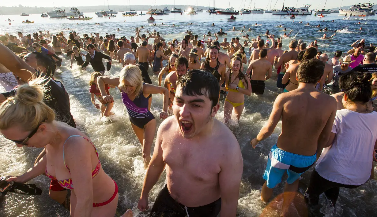 Ekspresi salah seorang peserta di English Bay saat ambil bagian dari acara tahunan Polar Bear Swim di Vancouver, Kanada (2/1/2016). Meski suhu di pantai tersebut mencapai 3 derajat celcius, mereka tetap antusias. (REUTERS / Ben Nelms)