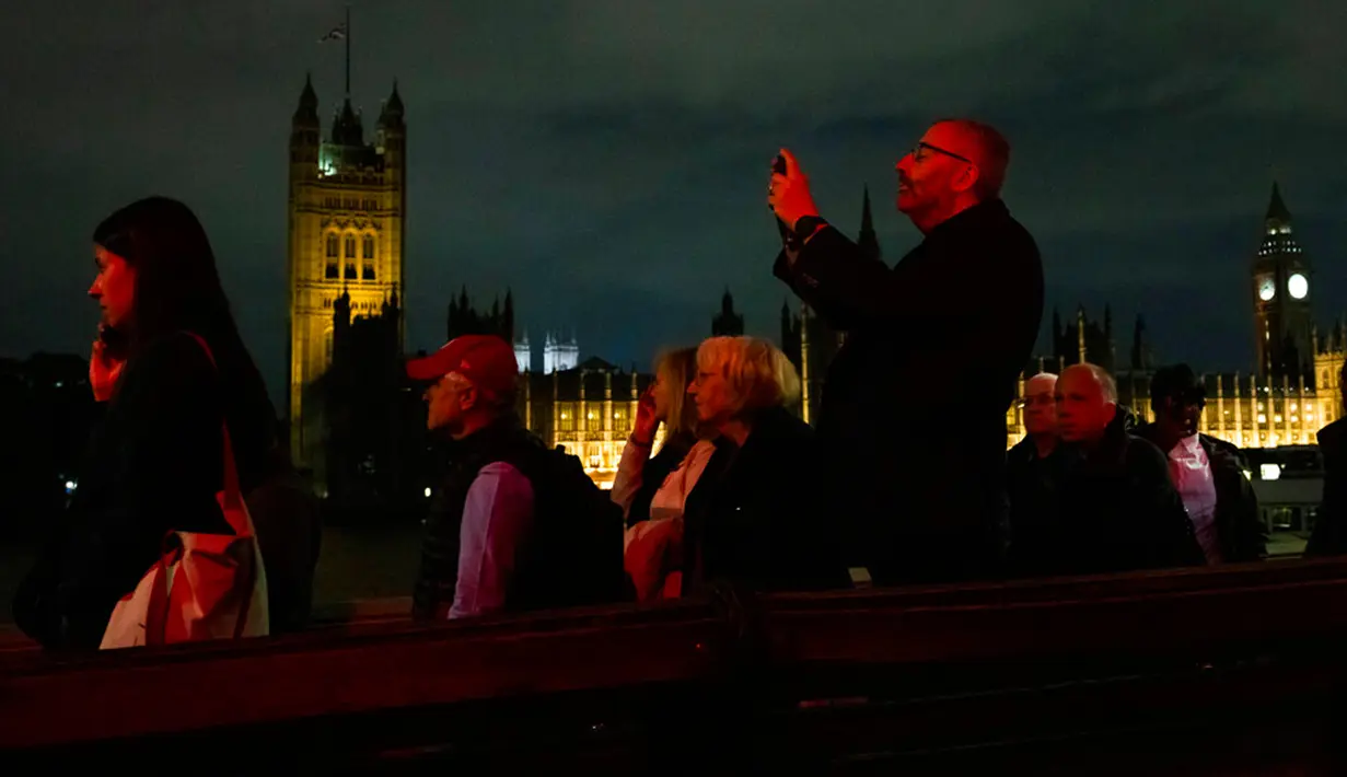 Seorang pria menunggu dalam antrean untuk memberikan penghormatan kepada mendiang Ratu Elizabeth II selama Lying-in State di luar Westminster Hall, London, Inggris, 15 September 2022. Sebanyak 1.000 petugas keamanan, pramugara, dan petugas polisi siap sedia sepanjang waktu selama 24 jam penuh untuk membantu mengelola antrean pelayat. (AP Photo/Nariman El-Mofty)