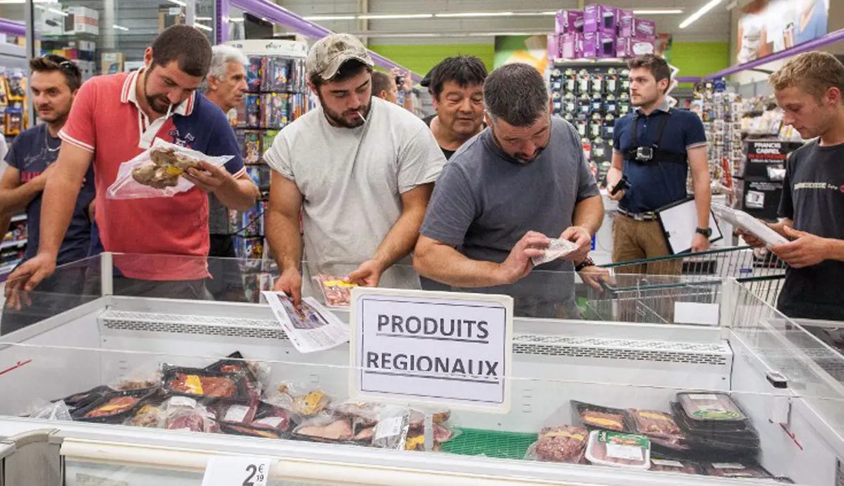 Petani memeriksa sejumlah produk daging di supermarket Casino di Sarlat, Perancis barat daya, saat melakukan aksi demo di supermarket tersebut, Kamis (20/8/2015). (AFP PHOTO/Yohan Bonnet)