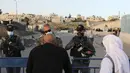 Anggota pasukan keamanan Israel berjaga-jaga di pos pemeriksaan Qalandia antara kota Ramallah Tepi Barat dan Yerusalem, ketika orang-orang Palestina menyeberang untuk menghadiri sholat Jumat kedua bulan Ramadhan di masjid Al-Aqsa, Jumat (23/4/2021). (ABBAS MOMANI / AFP)