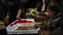 <p>Iuliia Loseva (kanan) bersama putranya Hryhorii dan Denys menangisi peti mati suami dan ayah mereka Volodymyr Losev (38) selama pemakamannya di sebuah pemakaman di Zorya Truda, wilayah Odesa, Ukraina, Senin, 16 Mei 2022. Volodymyr Losev, seorang tentara relawan Ukraina, tewas pada 7 Mei lalu ketika kendaraan militer yang dikendarainya menabrak sebuah ranjau di Ukraina timur. (AP Photo/Francisco Seco)</p>