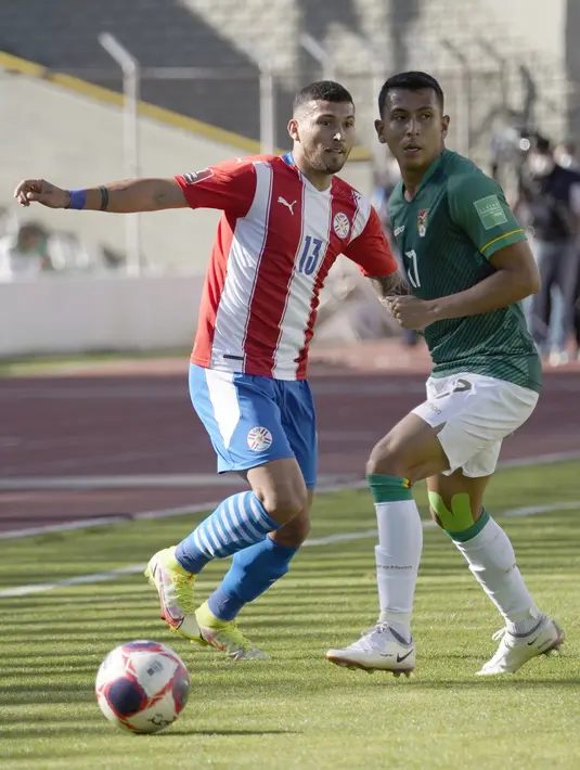 Pemain Bolivia Roberto Fernandez (kanan) berebut bola dengan pemain Paraguay Juan Escobar pada pertandingan kualifikasi Piala Dunia 2022 di Stadion Hernando Siles, La Paz, Bolivia, Kamis (14/10/2021). Bolivia menang 4-0. (Javier Mamani/Pool via AP)