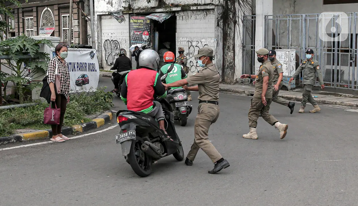 Petugas Satpol PP memberhentikan pengendara sepeda motor saat melakukan razia masker di kawasan Kota Tua, Jakarta, Kamis (24/2/2022). Perpanjangan PPKM level 3 untuk Jabodetabek berlaku selama sepekan, yakni sejak 22-28 Februari 2022 mendatang. (Liputan6.com/Faizal Fanani)