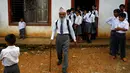Durga Kami berjalan keluar dari ruang kelasnya usai mengikuti pelajaran di SMA Shree Kala Bhairab di Syangja, Nepal, 5 Juni 2016. Siapa sangka kakek berusia 68 tahun itu ternyata seorang siswa kelas X. (REUTERS/Navesh Chitrakar)