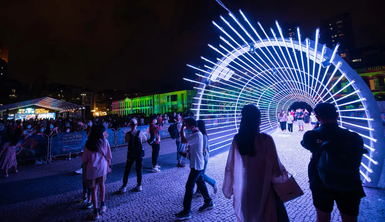 Orang-orang menikmati pemandangan malam di Festival Cahaya Makau 2020 yang digelar di Tap Seac Square, Makau, China selatan, pada 26 September 2020. Festival cahaya tersebut dimulai pada Sabtu (26/9) dan akan berlangsung hingga 31 Oktober. (Xinhua/Cheong Kam Ka)