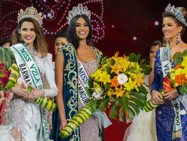 Kontestan asal Delta Amacuro, Sthefany Gutierrez (tengah) memegang bunga dan mengenakan mahkota saat dinobatkan sebagai Miss Venezuela 2017 di Caracas, Venezuela (9/11). (AFP Phot/STR)