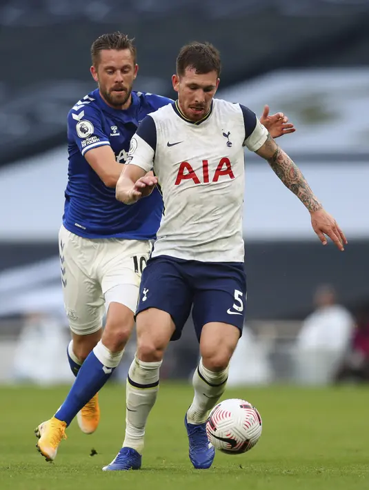 Pemain Tottenham Hotspur, Pierre-Emile Hojbjerg membawa bola dari kawalan pemain Everton, Gylfi Sigurdsson pada pertandinga Liga Inggris di i Stadion Tottenham Hotspur di London, Minggu, (13/9/2020). Everton menang 1-0 atas Totttenham. (Cath Ivill/Pool via AP)