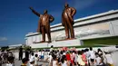 <p>Anak-anak menaruh bunga dekat patung mendiang pemimpin Kim Il Sung dan Kim Jong Il saat memperingati 25 tahun meninggalnya Kim Il Sung di Bukit Mansu, Pyongyang, Korea Utara, Senin (8/7/2019). (AP Photo/Jon Chol Jin)</p>