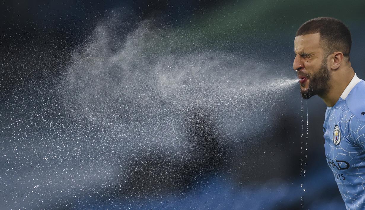 Bek Manchester City, Kyle Walker menyemburkan air dari mulutnya sebelum dimulainya laga melawan Wolverhampton Wanderers dalam laga lanjutan Liga Inggris 2020/21 pekan ke-27 di Etihad Stadium, Selasa (2/3/2021). Manchester City menang 4-1 atas Wolverhampton. (AP/Carl Recine/Pool)