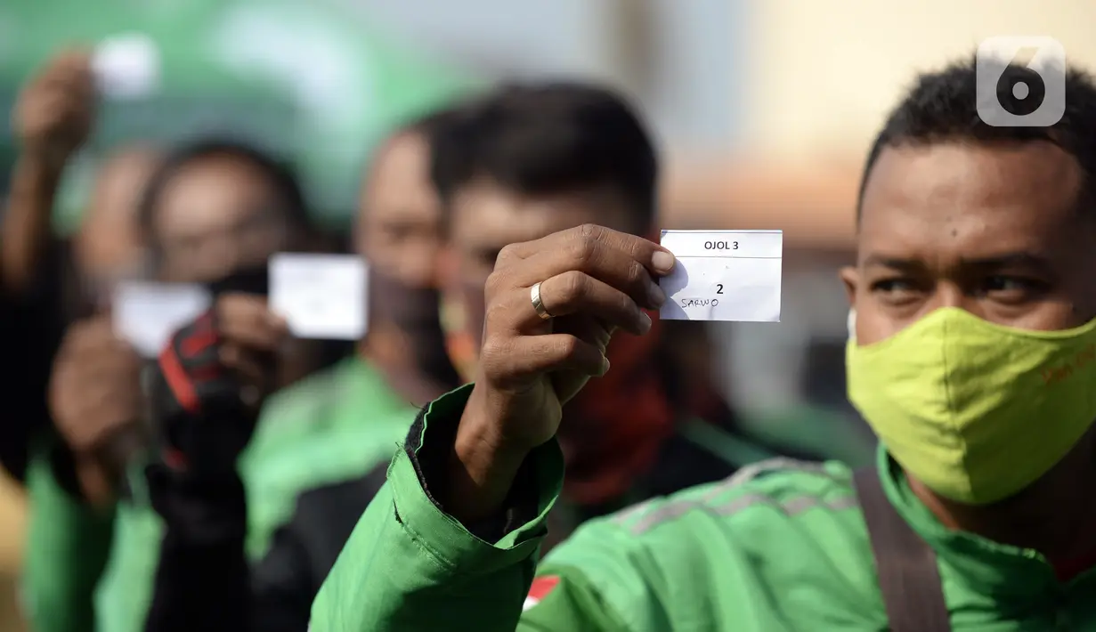 Pengemudi ojek online menunjukkan nomor antrean saat menjalani swab test COVID-19 di Alam Sutra, Tangerang Selatan, Banten, Selasa (21/7/2020). Swab test gratis tersebut digelar di tengah kasus COVID-19 yang terus bertambah di beberapa daerah di Indonesia. (merdeka.com/Dwi Narwoko)