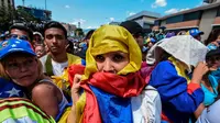 Demonstran mengenakan benedera Venezuela di kepalanya dalam aksi protes mendesak pengunduran diri Nicolas Maduro (AFP/Juan Baretto)