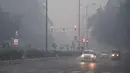 Kendaraan melintas saat asap tebal menyelimuti kota New Delhi, India (20/10). Polusi udara yang parah tersebut dikarenakan banyaknya kembang api yang dinyalakan selama Festival Diwali. (AFP Photo/Dominique Faget)