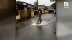 Tampaknya berselancar tak hanya bisa dilakukan di tengah laut. Saat banjir sekalipun, ternyata berselancar bisa dilakukan lho. Seperti yang dilakukan pria ini!