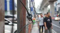 Instalasi kabel menjuntai di Jalan Panglima Polim, Kebayoran Baru, Jakarta, Kamis (31/10/2019). Buruknya pemasangan instalasi kabel di Ibukota menyebabkan banyak kabel yang menjuntai hingga mengganggu ketertiban umum. (Liputan6.com/Immanuel Antonius)