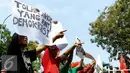 Pengunjuk rasa membawa poster saat melakukan aksi menolak Pergub 228 tahun 2015, Jakarta, Senin (9/11/2015). Pergub No. 228 tahun 2015 mengatur pelaksanaan penyampaian pendapat di muka umum yang disahkan pada 28 Oktober 2015. (Liputan6.com/Yoppy Renato)