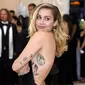 Penyanyi dan artis Hollywood, Miley Cyrus berpose setibanya pada ajang Met Gala 2018 di Metropolitan Museum of Art New York, Senin (7/5). Miley Cyrus tampil mengenakan gaun hitam yang memamerkan bagian punggung mulusnya. (Evan Agostini/Invision/AP)