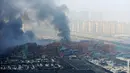 Kepulan asap terlihat membumbung di lokasi ledakan di pelabuhan Kota Tianjin, China, Kamis (13/8/2015). Ledakan yang diperkirakan berkekuatan setara 21 ton TNT ini menewaskan 17 orang dan ratusan lainya terluka. (REUTERS/Stringer CHINA OUT)