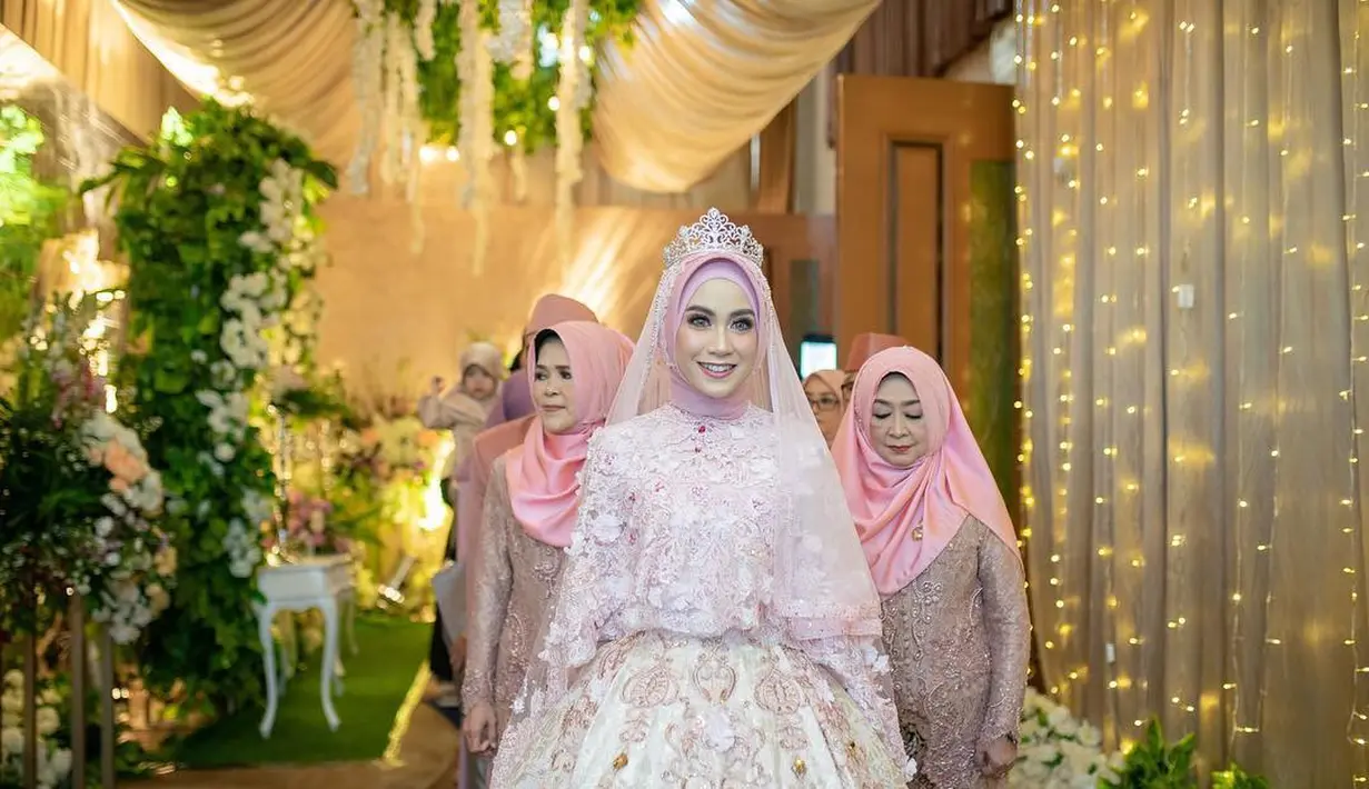 Eks personel Cherrybelle Anisa Rahma mengenakan lace cape ballgown berwarna soft pink dengan veil berhias bunga 3D. [Instagram/anisarahma_12]