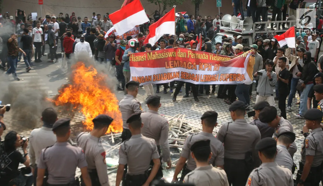 Massa membakar karangan bunga bernada dukungan dan keprihatinan di Gedung KPK, Jakarta, Jumat (13/9/2019). Polisi pun langsung membubarkan paksa massa pendukung dari revisi UU KPK tersebut dengan penembakan gas air mata hingga akhirnya bentrok. (Liputan6.com/HO/Andri)