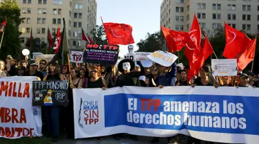 Sejumlah demonstran berunjuk rasa terhadap kesepakatan perdagangan Trans-Pacific Partnership (TPP) di depan gedung Pemerintah di Santiago, Chili, (4/2). Mereka membawa spanduk bertuliskan "The TPP mengancam hak asasi manusia". (REUTERS/Ivan Alvarado)