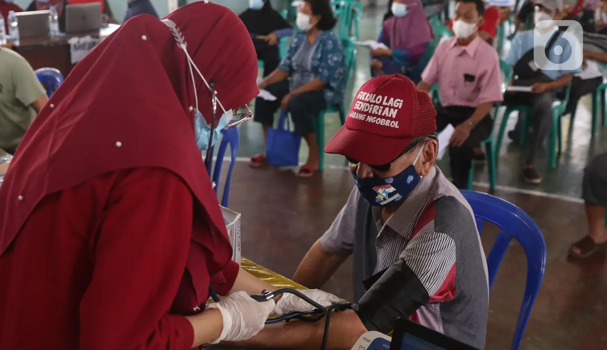 Petugas medis mengecek kesehatan seorang lansia sebelum melakukan vaksinasi Covid-19 di Gor Total Persada, Kota Tangerang, Selasa (8/6/2021). Vaksinasi tersebut untuk melindungi mereka dari Covid-19 yang tengah mewabah. (Liputan6.com/Angga Yuniar)