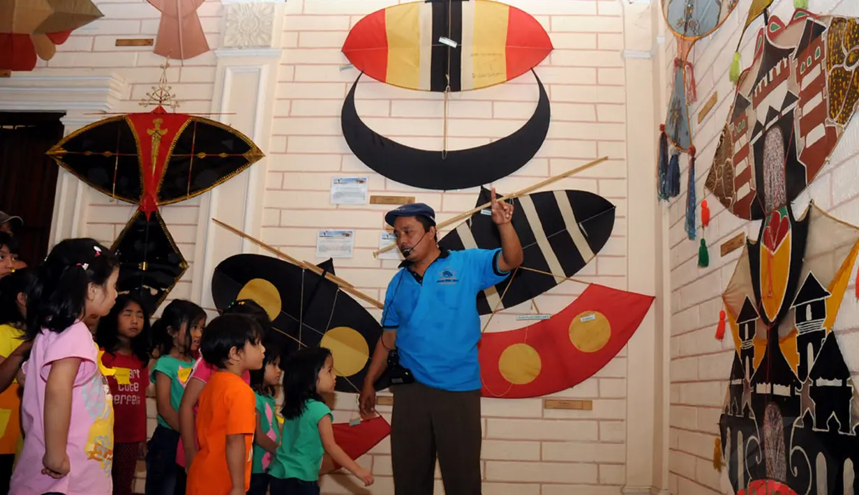 Bersama salah satu pemandu, sejumlah anak berkeliling dan melihat-lihat koleksi layang-layang yang ada di Museum Layang-Layang, Jakarta, (27/9/2014). (Liputan6.com/Helmi Fithriansyah)