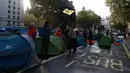 Aktivis iklim mengibarkan bendera ketika mereka berkemah di Whitehall, London, Inggris, Selasa (8/10/2019). Gerakan ini termasuk dalam pemberontakan internasional yang juga berlangsung di beberapa negara, seperti Australia dan Belanda. (AP Photo/Alastair Grant)