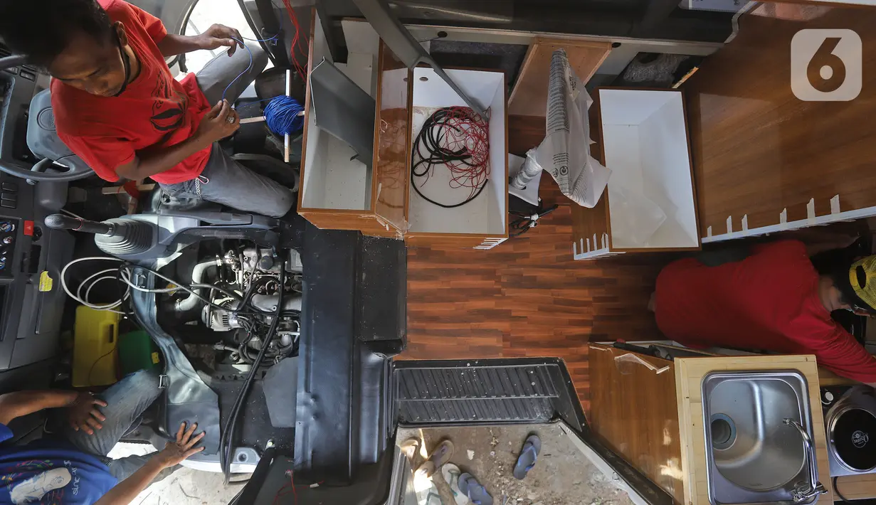 Pekerja menyelesaikan modifikasi mobil campervan di Bengkel Impro Campervan, Depok, Sabtu (14/11/2020). Pemilik bengkel mengatakan biaya modifikasi berkisar Rp50 juta hingga Rp200 juta itu mengalami peningkat permintaan sekitar 70 persen dari komunitas mobil campervan. (Liputan6.com/Herman Zakharia)