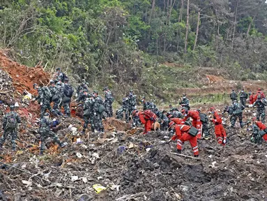 Petugas penyelamat mencari kotak hitam di lokasi kecelakaan pesawat di daerah Tengxian, Daerah Otonomi Guangxi Zhuang, China barat daya (22/3/2022). Pesawat Boeing 737-800 milik China Eastern Airlines yang mengangkut 132 orang jatuh di pegunungan Guangx pada 21 Maret 2022. (Zhou Hua/Xinhua via AP)