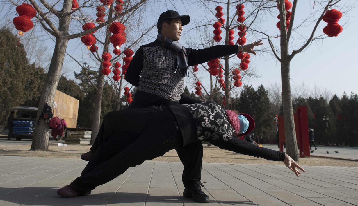 Seorang pria dan wanita berdansa di Ditan Park di Beijing (1/2). Tahun Baru Imlek jatuh pada 16 Februari tahun ini, dengan perayaan yang berlangsung selama seminggu di China. (AFP Photo/Nicolas Asfouri)