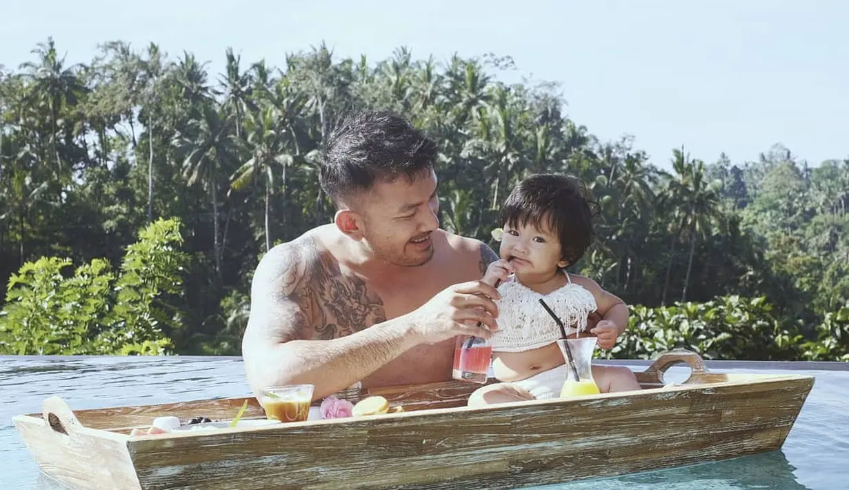 Rio berendam di kolam renang dengan telanjang dada sambil memegang gelas minum buah hatinya, warganet banyak yang gagal fokus dengan penampilan bintang film Filosofi Kopi itu. (Instagram/riodewanto)