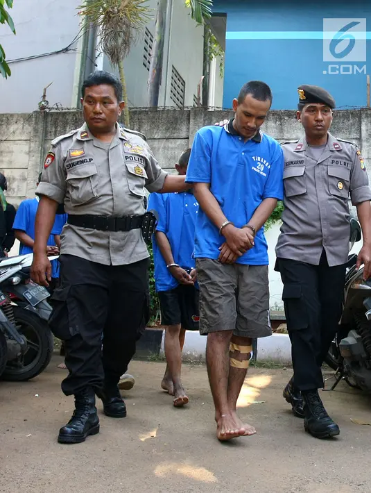 Polisi menggiring tersangka kejahatan begal spesialis handphone di Mapolsek Benda, Tangerang, Banten, Senin (19/11). Polisi menyita barang bukti handphone dan celurit. (Liputan6.com/Fery Pradolo)