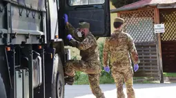 Tentara terlihat di dekat truk militer pembawa jenazah pasien COVID-19 dari Lombardia di Bologna, 31 Maret 2020. Jumlah kematian akibat COVID-19 di Italia pada Selasa (31/3) mencapai 837, sehingga totalnya menjadi 12.428 sejak pandemi itu kali pertama muncul di Italia utara. (Xinhua/Gianni Schicchi)