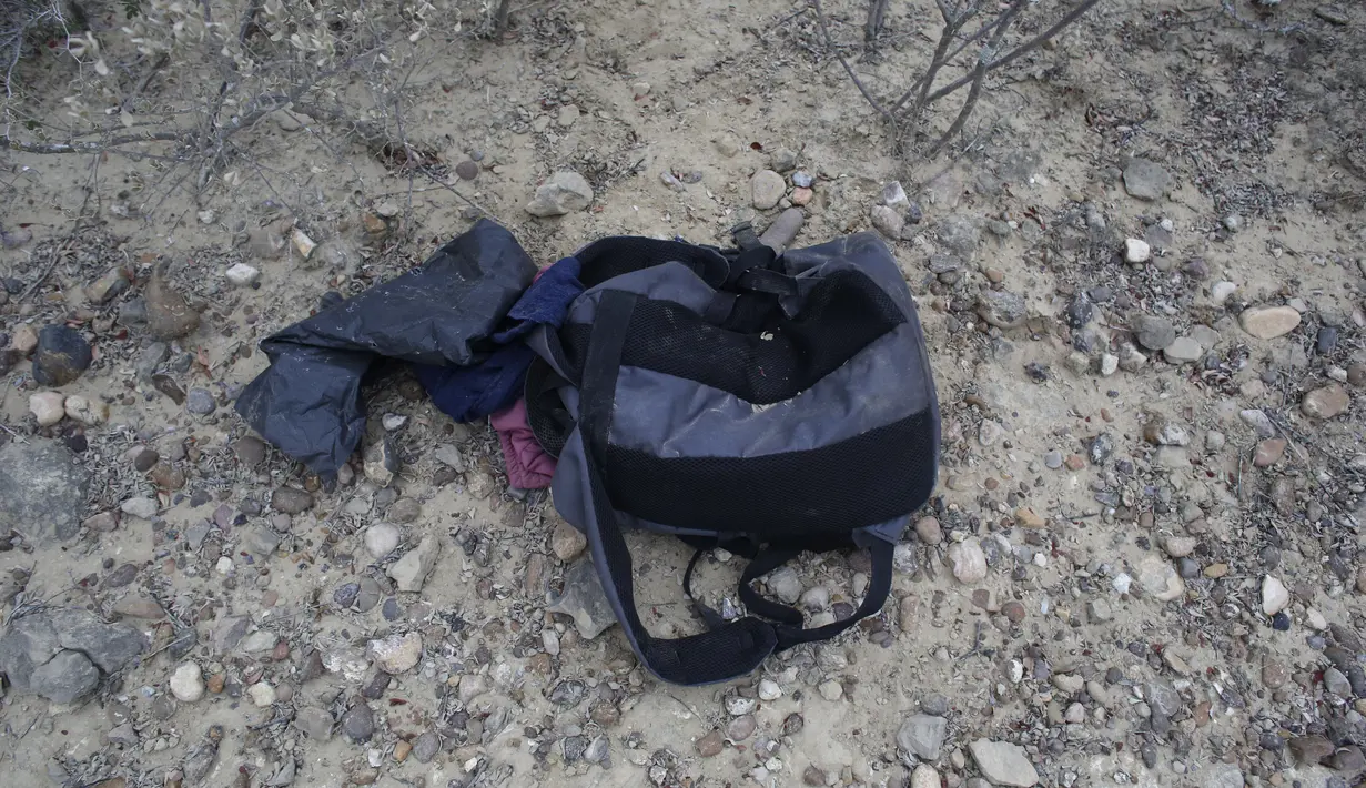 Sebuah ransel berisi pakaian tergeletak di tanah dekat tepi sungai Rio Grande di Roma, Texas, pada 28 Maret 2021. Saat kegelapan mulai terbenam di Rio Grande, aliran rakit yang membawa migran menyeberangi sungai ke tanah Amerika Serikat. (AP/Dario Lopez-Mills)